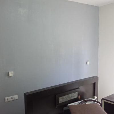 קיר צבוע בחדר עם מיטה ורהיטים