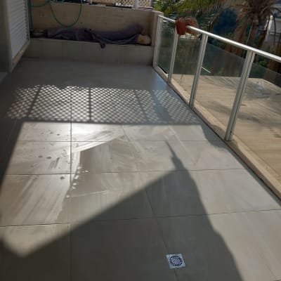 מרפסת עם ריצוף חדש ומעקה זכוכית