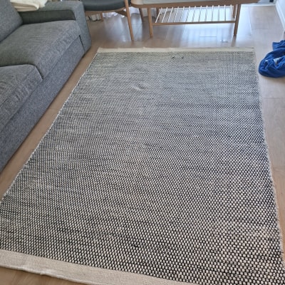 שטיח על רצפה ליד ספה ושולחן