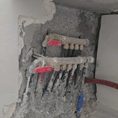 צנרת מים מותקנת בקיר עם ברזים אדומים