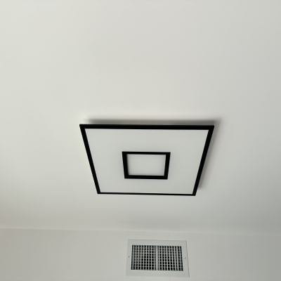 תאורה מרובעת על תקרה לבנה עם פתח אוורור