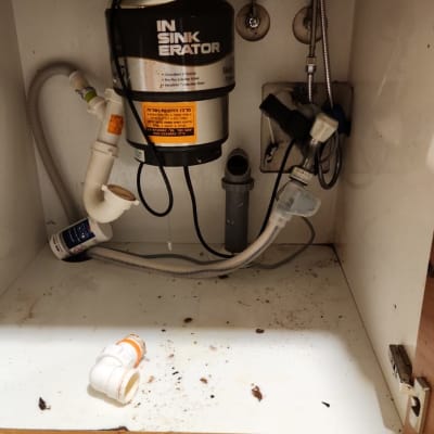 מתקן טוחן אשפה מתחת לכיור עם צינורות חיבור