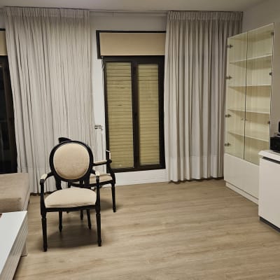 תריסים סגורים על חלון זכוכית עם וילונות לבנים