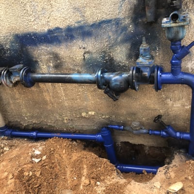 צנרת כחולה עם ברזים וקופסאות חיבורים על קיר