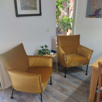 שני כיסאות מרופדים בצבע חום על רצפת עץ