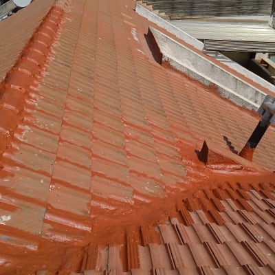 גג רעפים עם ציפוי אדום ואיטום סביב צינור