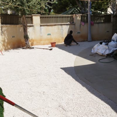 אדם עובד בגינה עם מגרפה ודלי