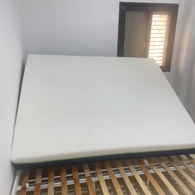 מזרן על מיטה בחדר עם חלון ומזגן