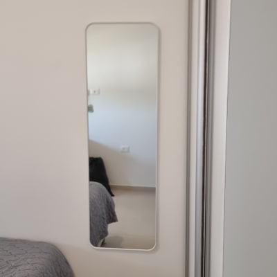 מראה מלבנית תלויה על קיר לבן