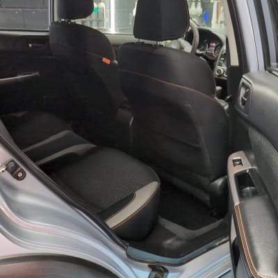 מושב אחורי של רכב עם ריפוד שחור ותפירה כתומה