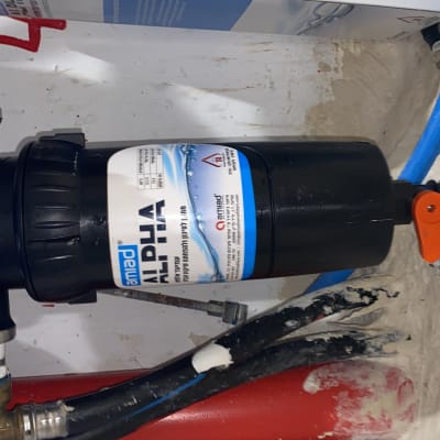 מסנן מים עם ברז כתום וצינורות כחולים