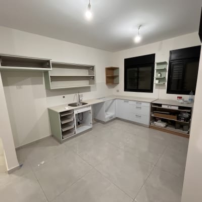מטבח חדש עם ארונות פתוחים ורצפה מבריקה