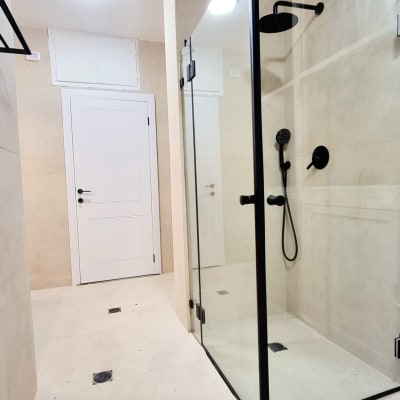 מקלחון זכוכית עם מסגרת שחורה וברז שחור