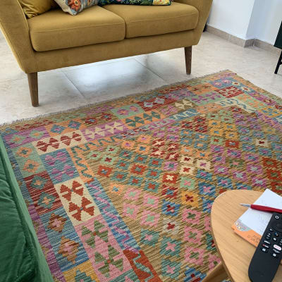 שטיח צבעוני על רצפה ליד ספה צהובה