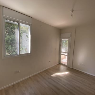 רצפת פרקט עץ בהירה בחדר ריק עם חלון ודלת