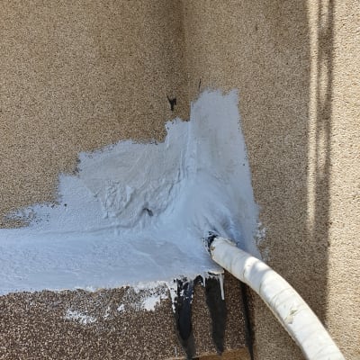 צינור אטום בחומר לבן על קיר חיצוני