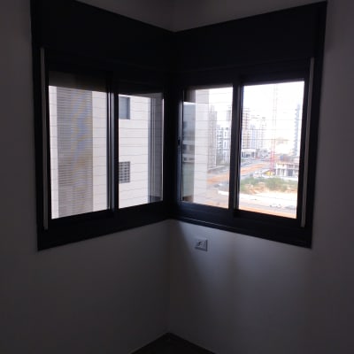 חלונות אלומיניום עם מסגרת כהה בחדר