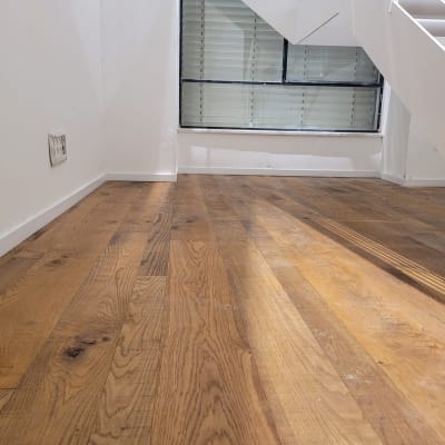 רצפת פרקט עץ חום בחדר עם קיר לבן