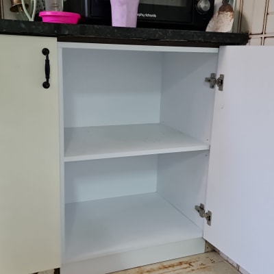 ארון מטבח פתוח עם מדפים ריקים ודלתות צירים