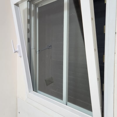 חלון פתוח עם תריסים לבנים על קיר פנימי