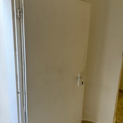 דלת לבנה עם ידית כסופה וקיר צבוע