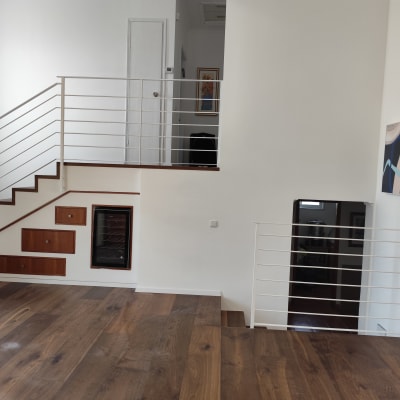 מעקה מתכת לבן על מדרגות עץ