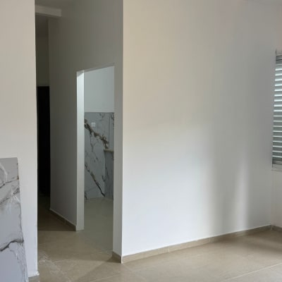 קיר לבן עם אריחים, דלי צבע אדום