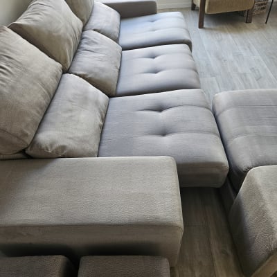 ספה אפורה גדולה עם כריות במרפסת מוארת