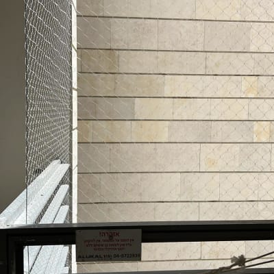 רשת מתכת למניעת כניסת יונים על קיר אבן