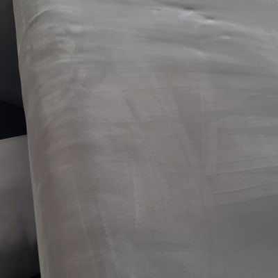 ספה אפורה עם סימני ניקוי נראים על הבד