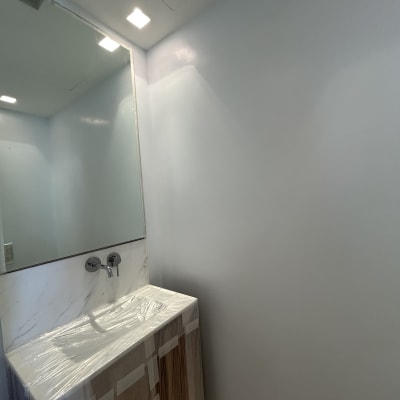 קיר צבוע בצבע בהיר ליד מראה ותאורה