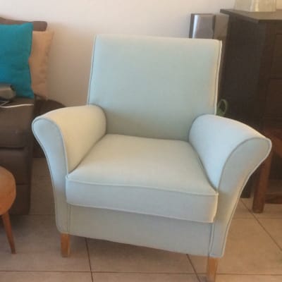 כורסה מרופדת בצבע תכלת עם רגלי עץ