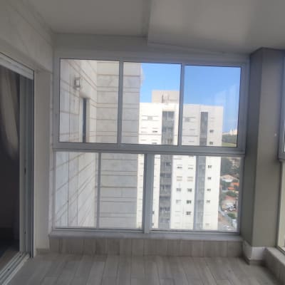 חלונות אלומיניום במרפסת סגורה עם נוף עירוני