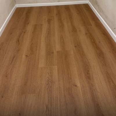 רצפת פרקט חומה בחדר עם קירות בהירים