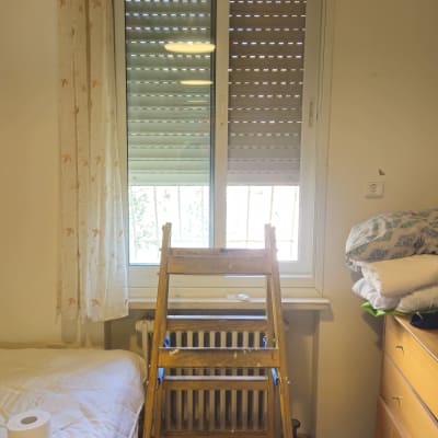 סולם מול חלון עם תריסים בחדר