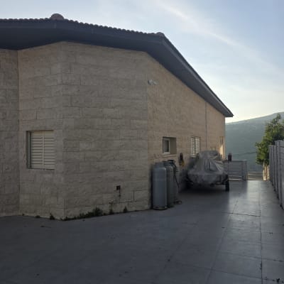 בית עם קיר אבן ומיכלי גז בחצר