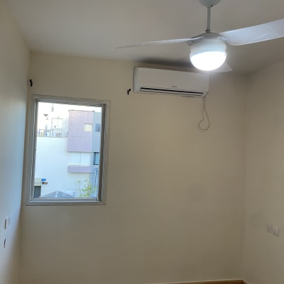 חדר ריק עם מאוורר תקרה ומזגן על הקיר