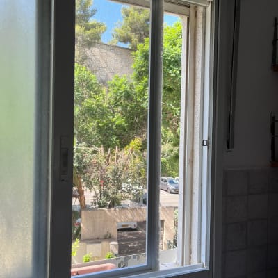 חלון אלומיניום פתוח עם מסגרת לבנה