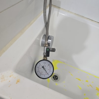 מד לחץ מים באמבטיה עם כתמים צהובים