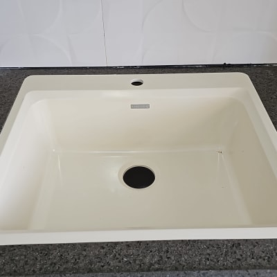 כיור משובץ בשיש כהה עם רקע לבן