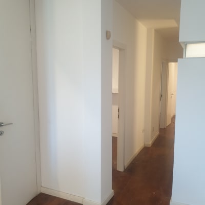 קירות צבועים בלבן במסדרון עם רצפת עץ כהה