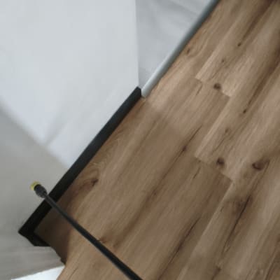 ריסוס חומר הדברה על רצפת עץ ליד קיר לבן