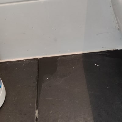 רצפה שחורה עם סימני לכלוך ליד קיר לבן