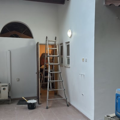 סולם, דלי צבע, אריחים וכלי עבודה בחצר