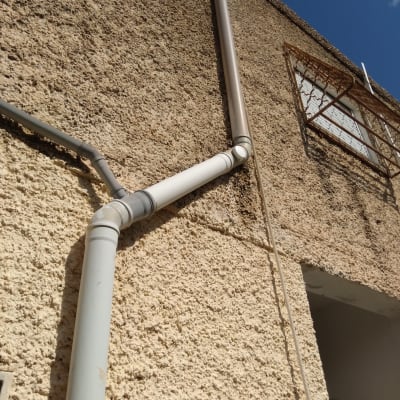 צינורות פלסטיק מותקנים על קיר חיצוני של בניין