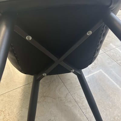 מבט מחלקו התחתון של כיסא מרופד בעור שחור עם רגלי מתכת