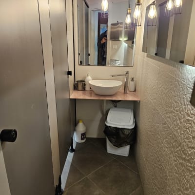 חדר שירותים עם כיור, מראה ותאורה תלויה