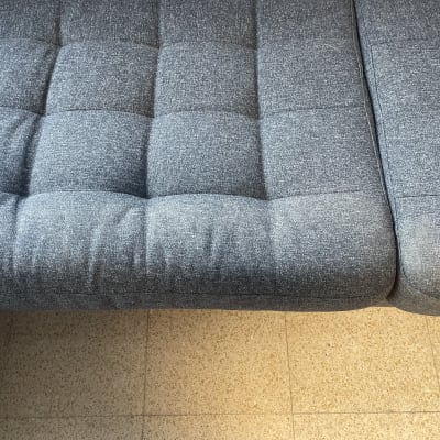 ספה אפורה עם ריפוד מרובע על רצפת אריחים