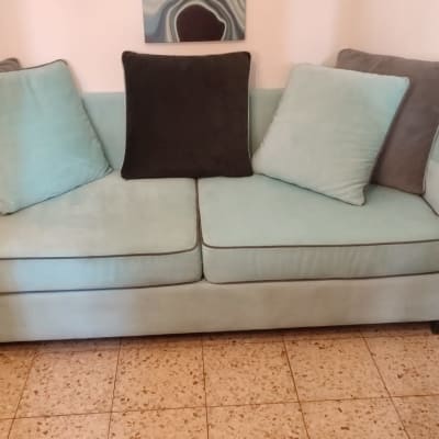 ספה עם כריות בצבעים שונים על רצפת אריחים