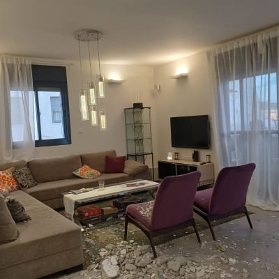 סלון עם תקרה פגומה ופסולת על הרצפה